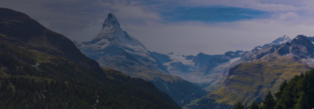 Schweizer Berggipfel mit grünen Wäldern am Fuße und klarem blauen Himmel, der Verbindung und Erreichbarkeit repräsentiert