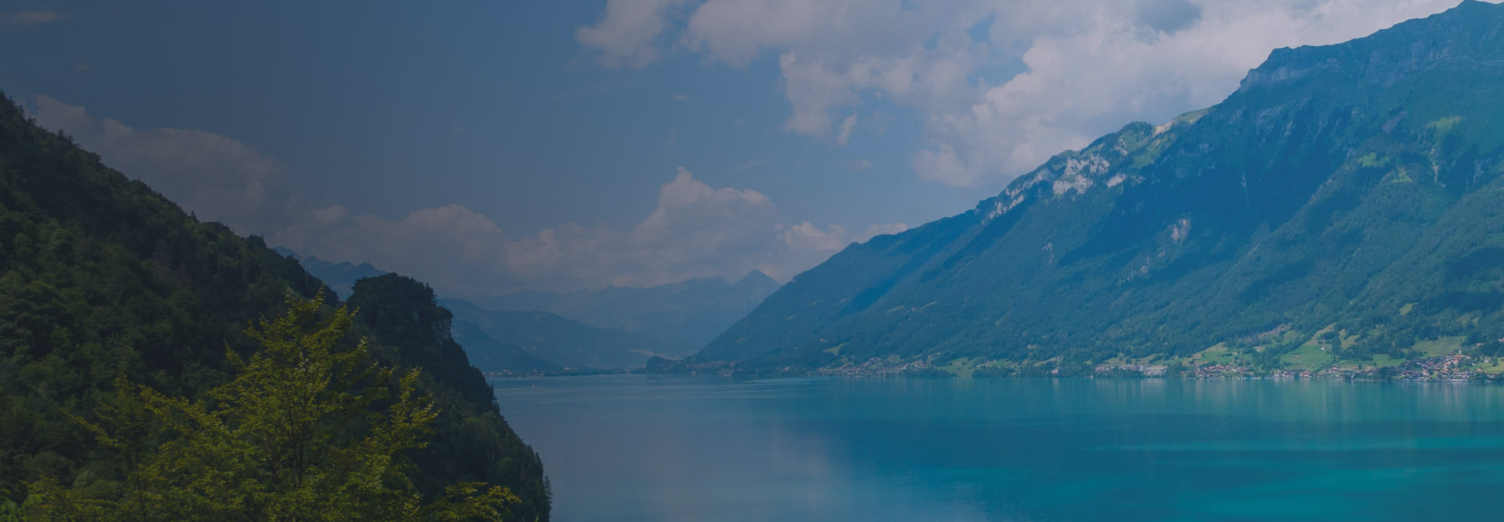 Schweizer Bergsee, umgeben von Gipfeln und Hügeln, der Klarheit und Tiefe widerspiegelt